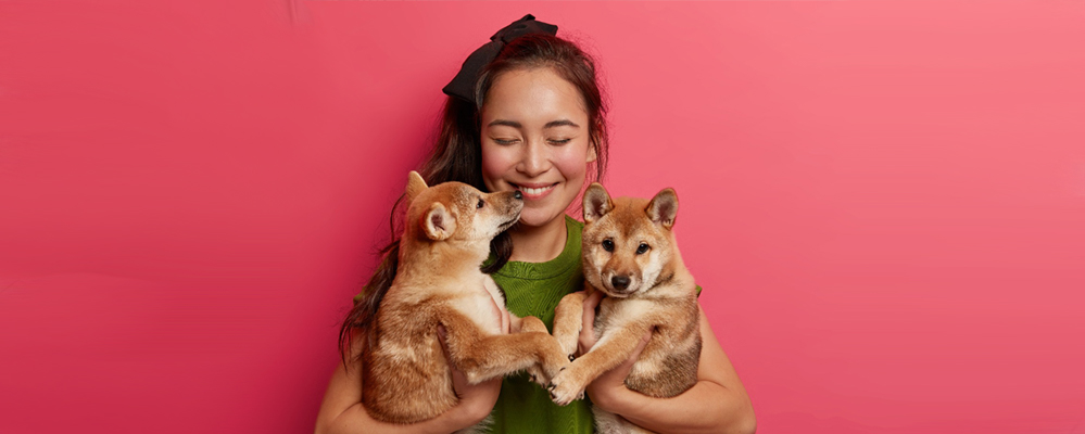 menina carrega dois cachorros