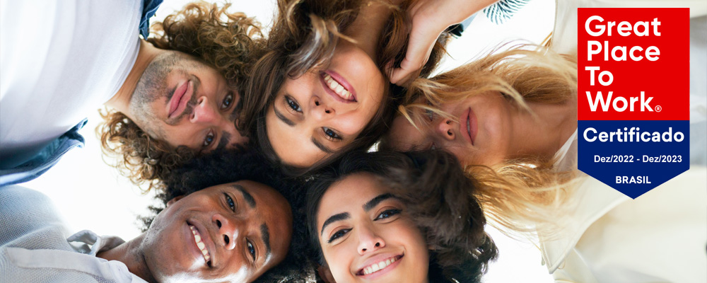 grupo de pessoas sorrindo e selo da GPTW