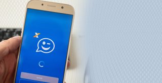 pessoa segura celular com o ícone do auxílio