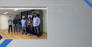 Da esquerda para direita, o diretor de Infraestrutura Alexandre Gedanken, a coordenadora de CGTIC/SMIT Sarah de Oliveira Alcantara Martins, o gerente de Telecomunicações Mauricio Hanashiro e demais membros de CGTIC/SMIT em frente às OLTs da Prodam.