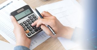 imagem de uma mão operando uma calculadora